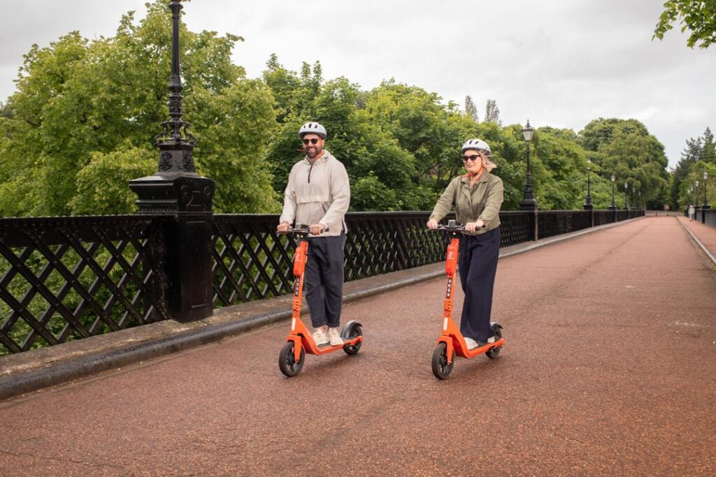 Two people on Neuron e-scooters