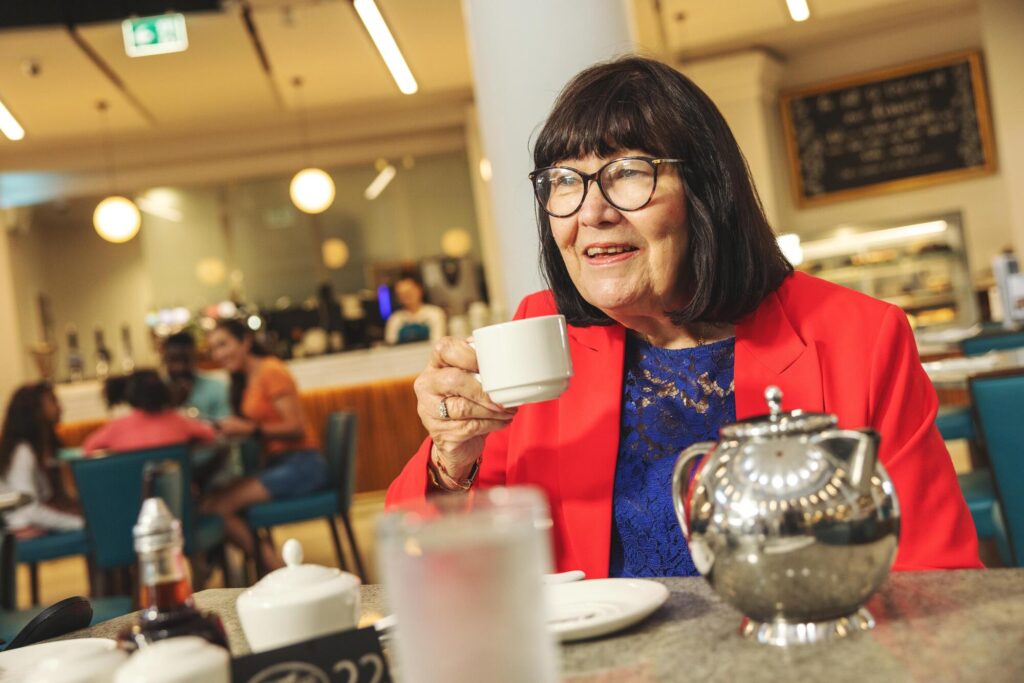 Woman drinking from a teacup in a cafe.