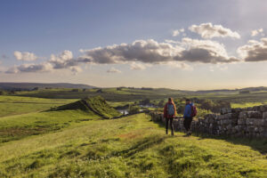 One male and onel female dressed in warm clothing walking Cawfields Quarry Hadrians Wall Northumberland